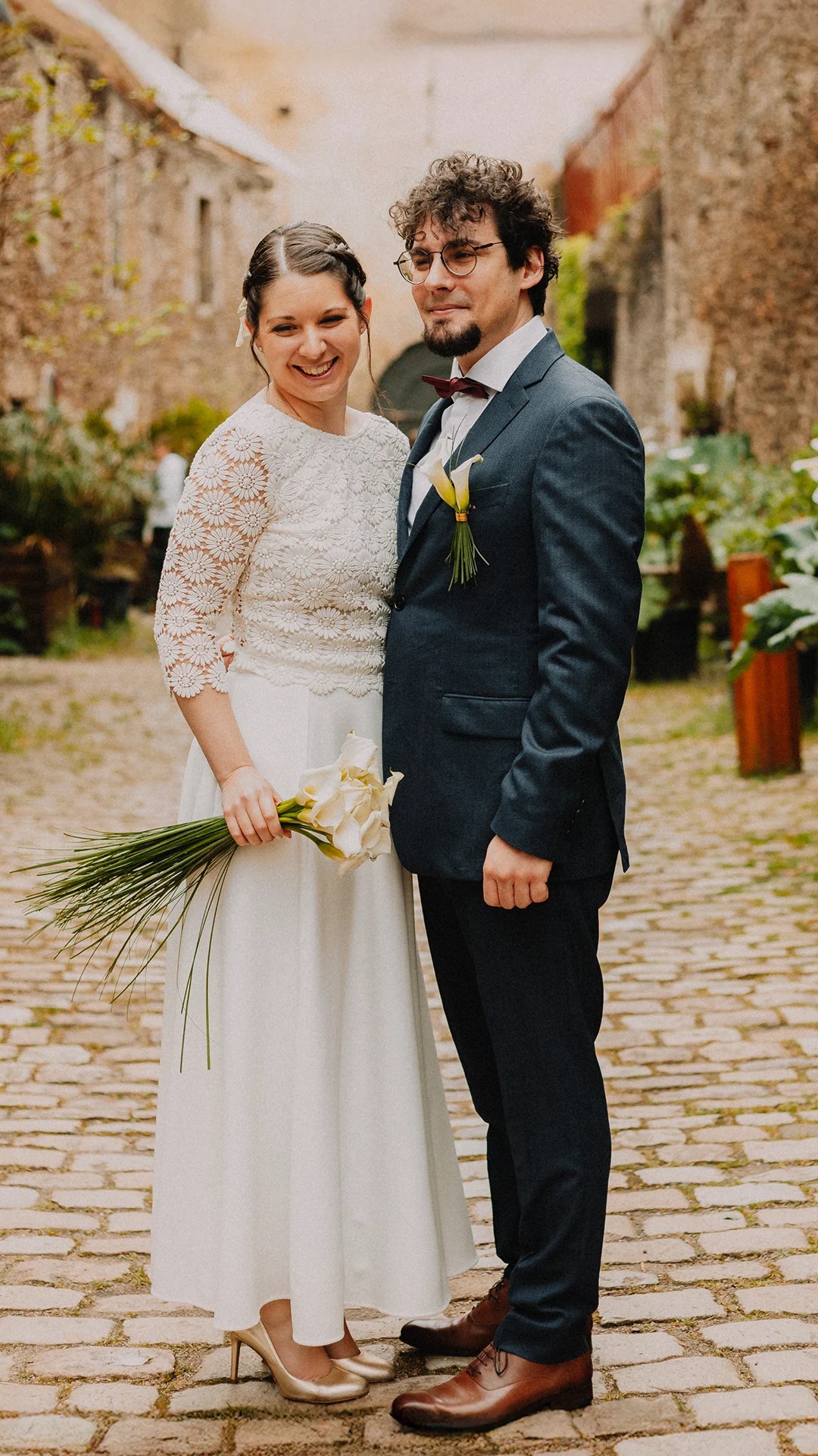 Jeune couple le jour de leur mariage à Brest, instant complice dans une ruelle pavée